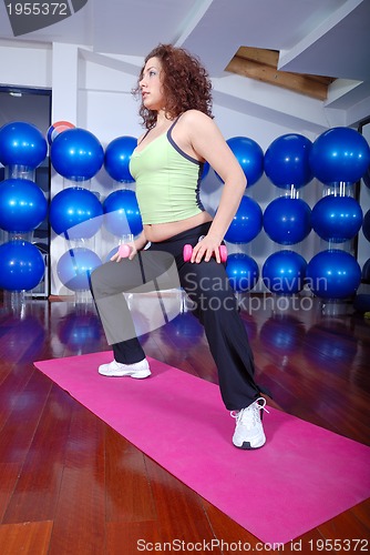 Image of young pretty woman exercising in a fitness center