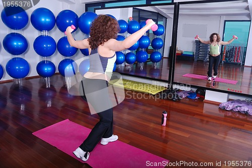 Image of young pretty woman exercising in a fitness center