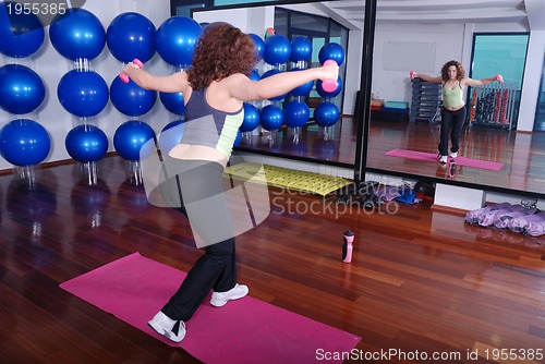 Image of young pretty woman exercising in a fitness center