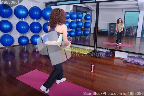 Image of young pretty woman exercising in a fitness center