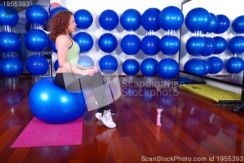 Image of young pretty woman exercising in a fitness center