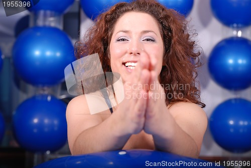 Image of young woman exercising with pilates ball