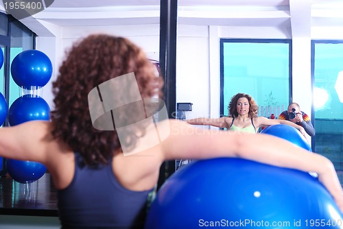 Image of young woman exercising with pilates ball