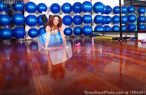 Image of young pretty woman exercising in a fitness center