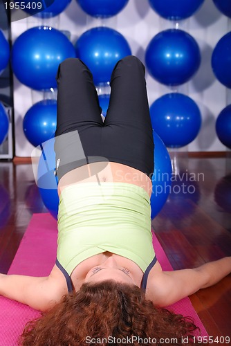 Image of young pretty woman exercising in a fitness center