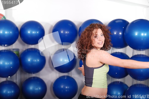 Image of young pretty woman exercising in a fitness center