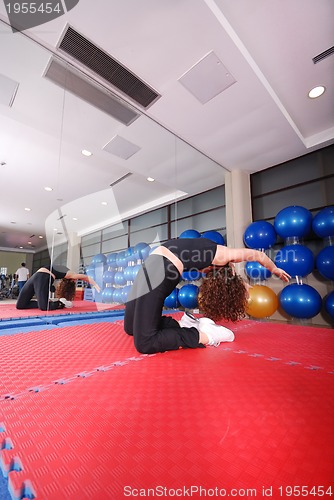 Image of pretty girl warming up in fitness studio