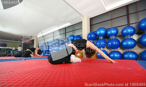 Image of pretty girl warming up in fitness studio