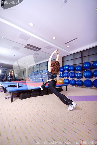 Image of pretty girl warming up in fitness studio