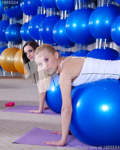 Image of beautiful young girls working out in a gym