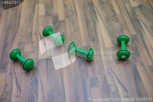 Image of green dumbbells on patquet floor