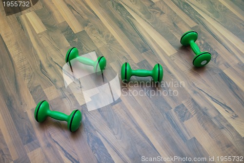 Image of green dumbbells on patquet floor