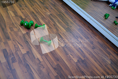 Image of green dumbbells on patquet floor