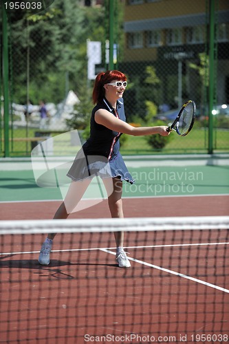 Image of young woman play tennis game outdoor