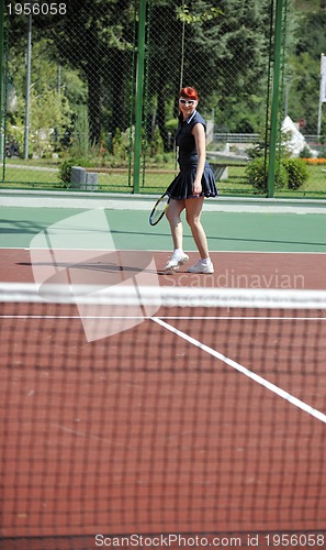 Image of young woman play tennis game outdoor