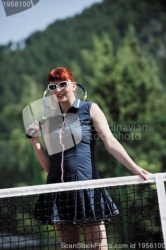 Image of young woman play tennis game outdoor