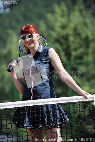 Image of young woman play tennis game outdoor