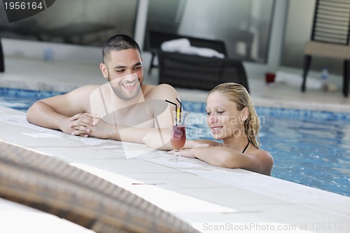 Image of happy cople relaxing  at swimming pool