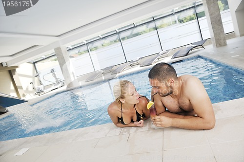 Image of happy cople relaxing  at swimming pool