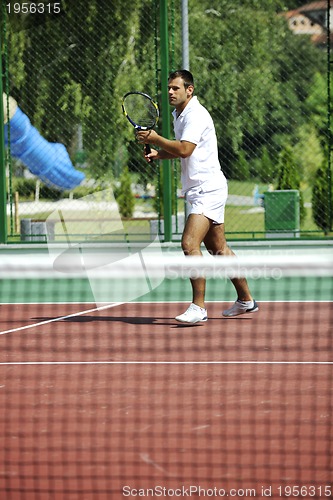 Image of young man play tennis outdoor