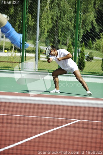 Image of young man play tennis outdoor
