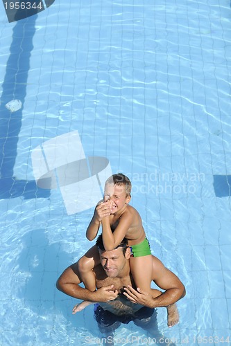 Image of happy father and son at swimming pool