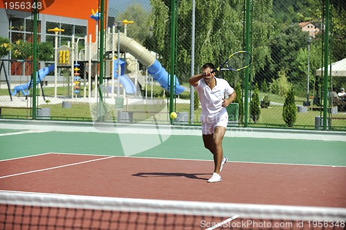 Image of young man play tennis outdoor