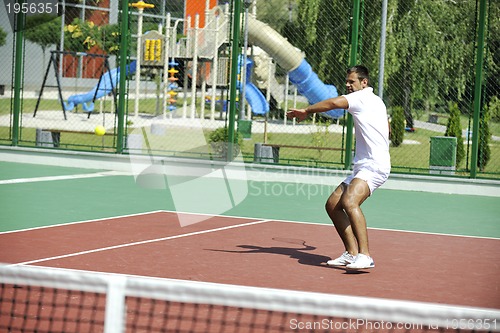Image of young man play tennis outdoor