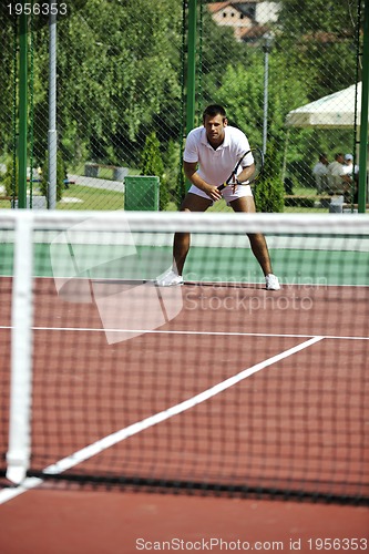 Image of young man play tennis outdoor