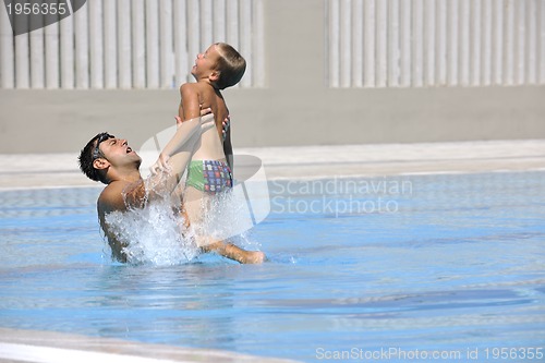 Image of happy father and son at swimming pool