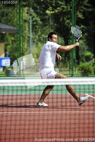 Image of young man play tennis outdoor