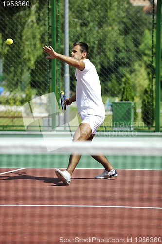 Image of young man play tennis outdoor