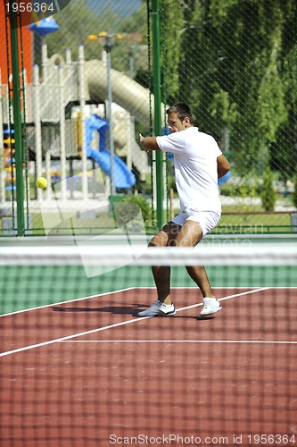 Image of young man play tennis outdoor