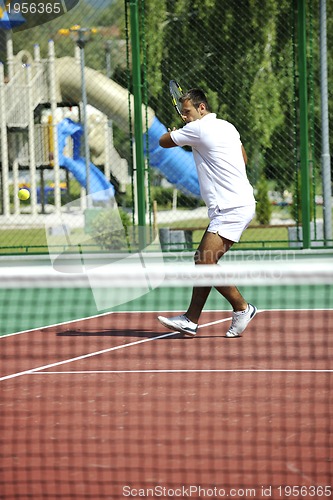 Image of young man play tennis outdoor