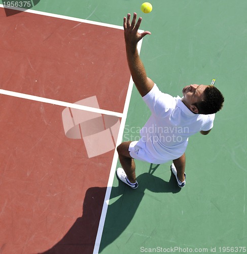 Image of young man play tennis outdoor