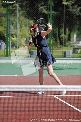 Image of young woman play tennis game outdoor