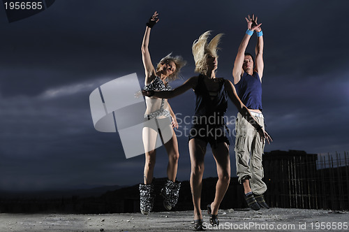 Image of group of people jumping in air in night