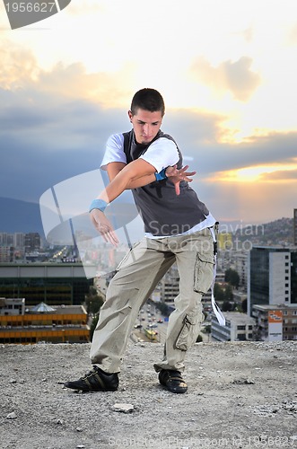 Image of young man jumping in air outdoor at night ready to party