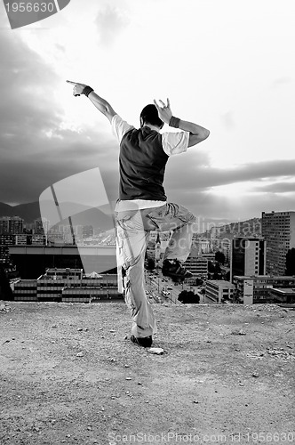 Image of young man jumping in air outdoor at night ready to party