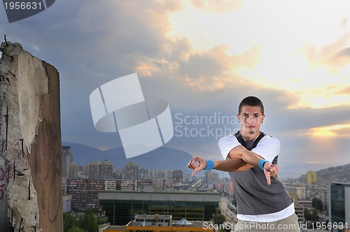 Image of young man jumping in air outdoor at night ready to party