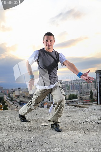 Image of young man jumping in air outdoor at night ready to party