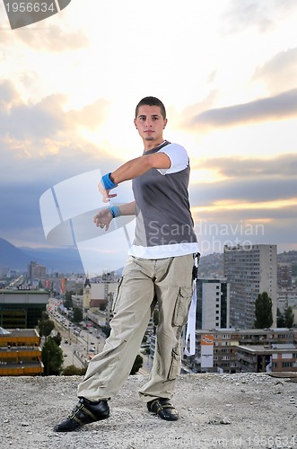 Image of young man jumping in air outdoor at night ready to party