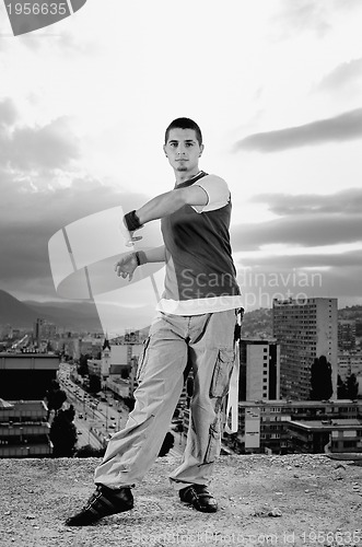 Image of young man jumping in air outdoor at night ready to party