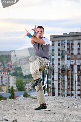 Image of young man jumping in air outdoor at night ready to party