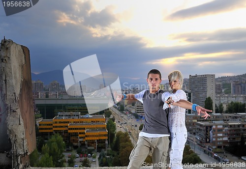 Image of romantic urban couple dancing on top of  bulding