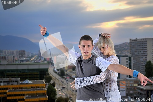 Image of romantic urban couple dancing on top of  bulding