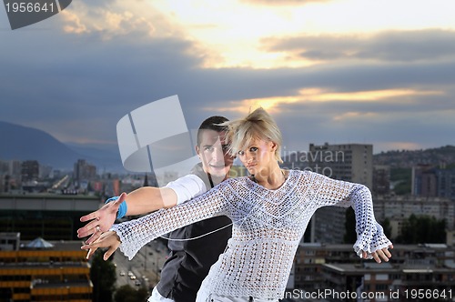 Image of romantic urban couple dancing on top of  bulding