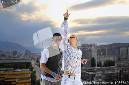 Image of romantic urban couple dancing on top of  bulding