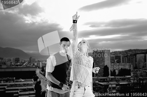 Image of romantic urban couple dancing on top of  bulding