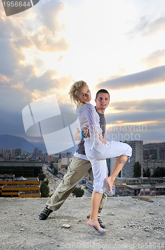 Image of romantic urban couple dancing on top of  bulding
